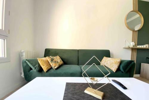 - un salon avec un canapé vert et un miroir dans l'établissement Cocon Elephant, à Nantes