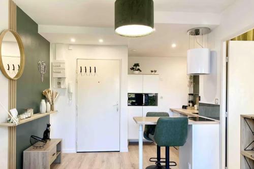 une cuisine avec un réfrigérateur blanc et une table dans l'établissement Cocon Elephant, à Nantes