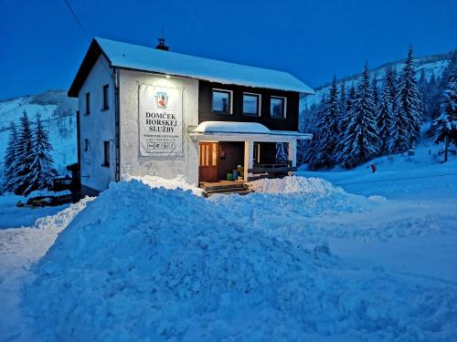 a building with a pile of snow in front of it at Domček Horskej Služby in Vyšná Boca