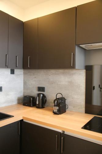 une cuisine avec des comptoirs en bois et des armoires noires dans l'établissement 2P au coeur du Vieil Antibes, à Antibes