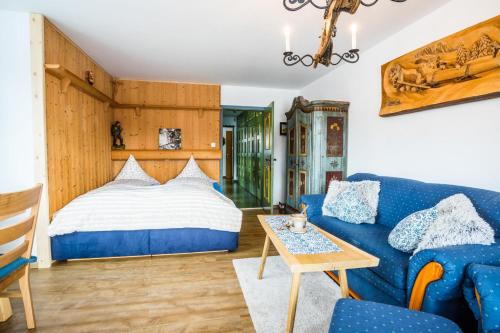 salon z niebieską kanapą i łóżkiem w obiekcie Appartement Amalie by MoniCare w mieście Seefeld in Tirol