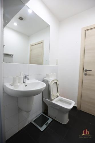 biała łazienka z umywalką i toaletą w obiekcie Gallery Cozy Abode w Akrze