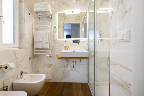 a white bathroom with a sink and a shower at Domus Uffizi in Florence