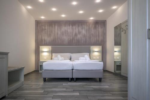 a bedroom with a large white bed with two pillows at Hotel Villa Paradiso Suite in Moniga