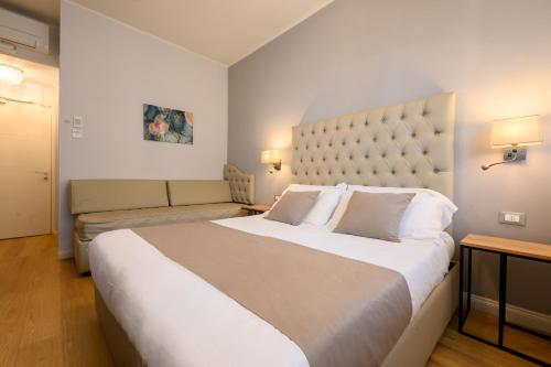 a hotel room with a large bed and a couch at Domus Uffizi in Florence