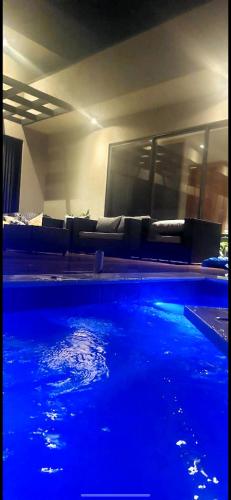 a swimming pool with blue water in a room at Chácara Recanto Pérola in Trindade