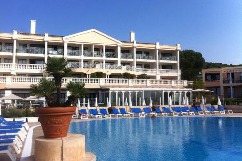 un hôtel avec une plante en pot en face d'une piscine dans l'établissement Sea views and beautiful pool, à Cannes