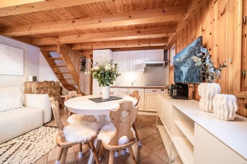 une cuisine et un salon avec une table et des chaises dans l'établissement Apartment Kozi, Méribel - by EMERALD STAY, à Les Allues