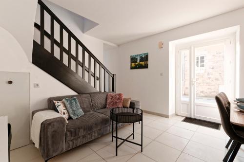 un salon avec un canapé et une table dans l'établissement La Caulnaise - Maison climatisée avec terrasse, à Caulnes