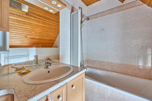 a bathroom with a sink and a bath tub at La Maison de Lallier - à 35 min de Cherbourg in Turqueville