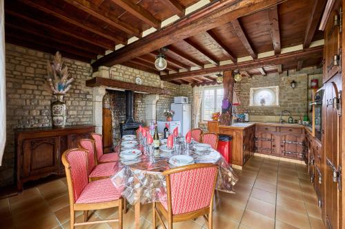 une salle à manger avec une table et des chaises dans une cuisine dans l'établissement La Maison de Lallier - à 35 min de Cherbourg, à Turqueville