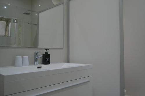 a bathroom with a white sink and a mirror at 4 Piet Retief in Stellenbosch