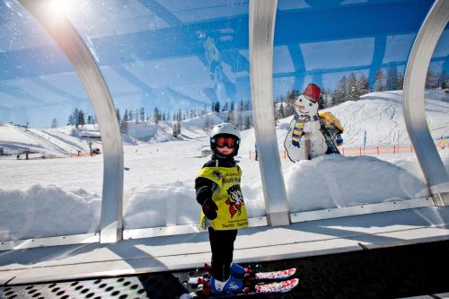 a young child standing in front of a snow man at Familien Zeit in Bad Mitterndorf