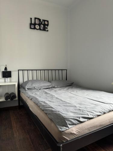 ein Bett in einem Schlafzimmer mit einem Schild an der Wand in der Unterkunft Paris Rooms -Rynek Centrum -F VAT in Kielce