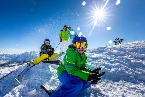 a group of people sitting on top of a snow covered slope at Familien Zeit in Bad Mitterndorf