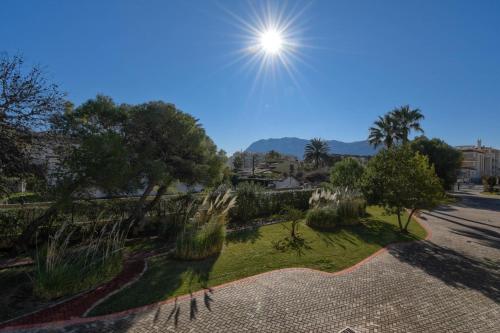 a view of a park with trees and the sun at Strandapartment Sunnybeach Dénia in Denia