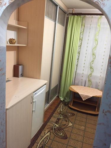 cocina con mesa y cortina verde en Мини-Квартира SMART-2 Mc-Donald's Іванни Блажкевич-2, en Ternopilʼ
