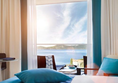 a room with a large window with a view of the ocean at Sun Gardens Dubrovnik in Dubrovnik