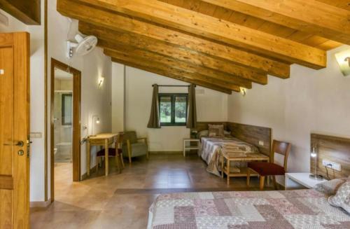 Un dormitorio con dos camas y techo de madera. en Casa rural Mas Plantalech, en Girona