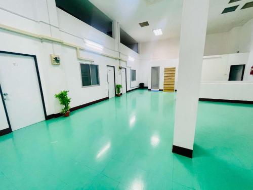 an empty room with a green floor in a building at Lamoon Center Point in Hat Yai