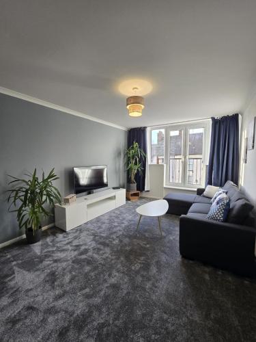 a living room with a couch and a tv at Flat in Northampton -Town Center in Northampton