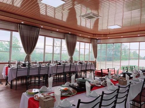 a large banquet hall with tables and chairs and windows at Khu du lịch sinh thái Núi Ngăm in Nam Ðịnh