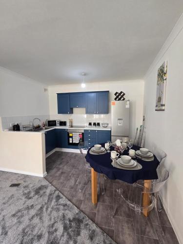 a kitchen with a dining room table with blue cabinets at Flat in Northampton -Town Center in Northampton