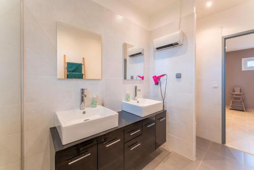 a bathroom with two sinks and a shower at Maison Marquet in Beaucaire