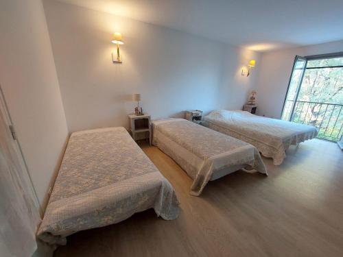 une chambre avec deux lits et une fenêtre dans l'établissement Cinette - Climatisation & Piscine chauffée, à Cotignac