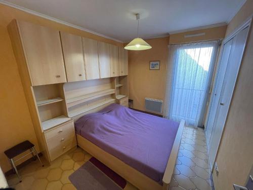 - une petite chambre avec un lit violet et des armoires dans l'établissement 4SOMA7 - Appartement avec jolie vue sur les collines, à Collioure