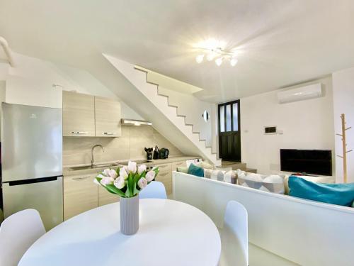 a kitchen and dining room with a white table and chairs at maison de geraldine in Cadorago