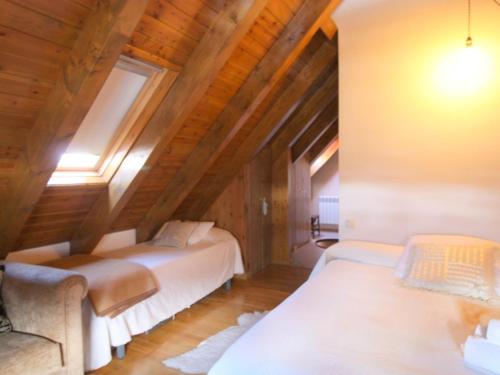 una camera con due letti in mansarda di Homenfun Baqueira Beret Vielha III a Betrén