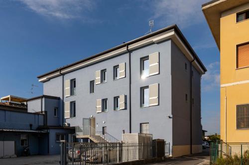 a large white building with windows on a street at Residence - LA ROSA DEI VENTI in Ghedi