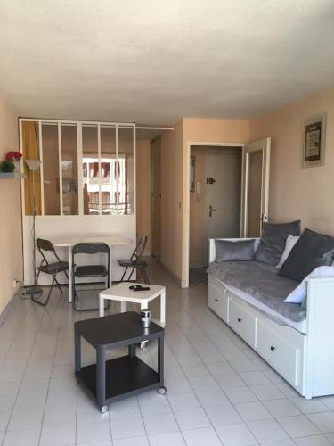 un salon avec un canapé et une table dans l'établissement Fréjus, 200 m des plages appart f1 avec piscine, à Fréjus