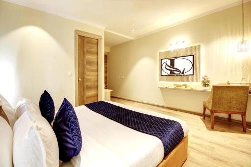 a hotel room with a bed and a desk at Limewood Stay Mall 51 in Gurgaon