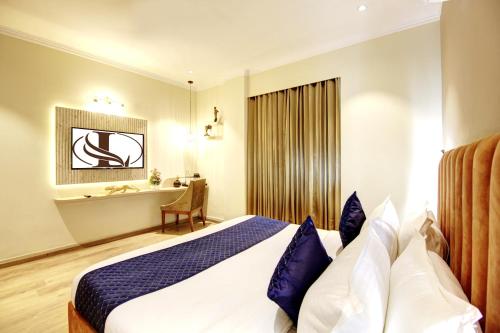 a hotel room with a bed and a desk at Limewood Stay Mall 51 in Gurgaon