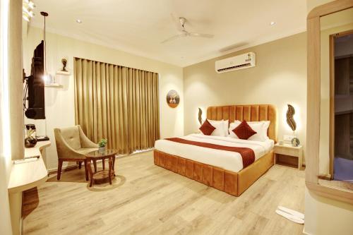 a hotel room with a bed and a desk and a chair at Limewood Stay Mall 51 in Gurgaon