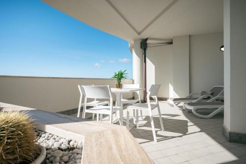 a patio with a table and chairs on a balcony at Milena Suite Apartments in Alghero