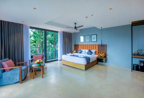 a bedroom with a bed and a couch and chairs at Vbrings Oak Village in Munnar