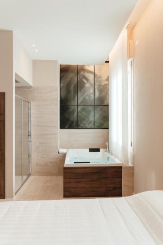 a white bathroom with a tub and a sink at Wine & Wellness in Villalta
