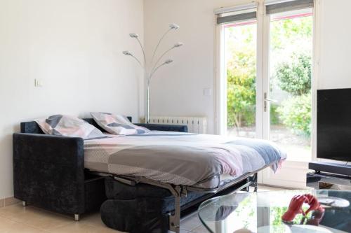 un lit dans une chambre avec une grande fenêtre dans l'établissement Detached villa with pool in Cazilhac, à Cazilhac