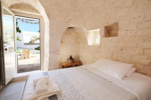 a bedroom with a white bed and a large window at Borgo San Francesco in Locorotondo