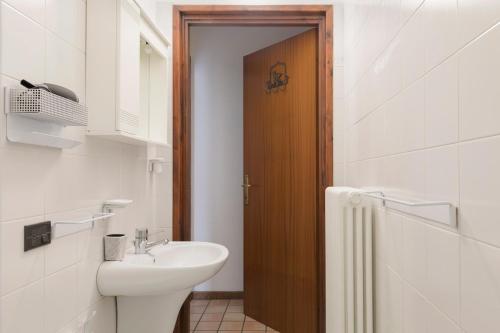 a bathroom with a sink and a wooden door at Carlo's Home - Como Centre 5 min from Train Station in Como