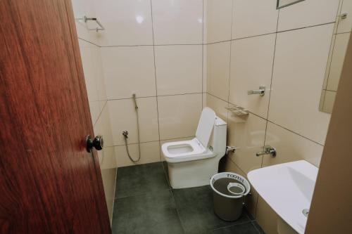 a bathroom with a toilet and a sink at Atland Residency in Calicut