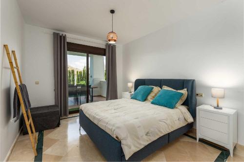 a bedroom with a large bed with blue pillows at Albatros in Casares