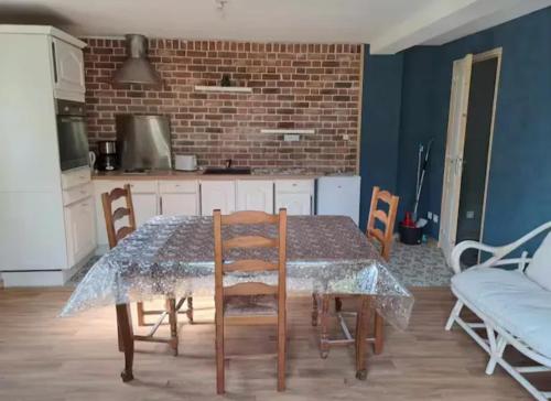 - une cuisine avec une table à manger et une table en verre dans l'établissement Maison charmante à Audignies, 50 m² avec jardin clôturé., à Mecquignies