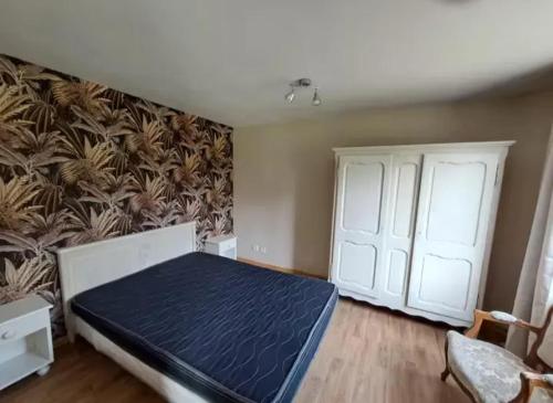 une chambre avec un lit et un mur dans l'établissement Maison charmante à Audignies, 50 m² avec jardin clôturé., à Mecquignies