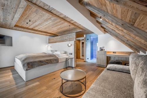 a bedroom with a bed and a couch at Sport- und Genusshotel Silvretta in Ischgl