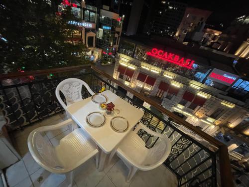 a white table and chairs on a balcony at night at Fountain Square appartment-2 in Baku