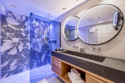 a bathroom with a sink and a mirror at Sport- und Genusshotel Silvretta in Ischgl